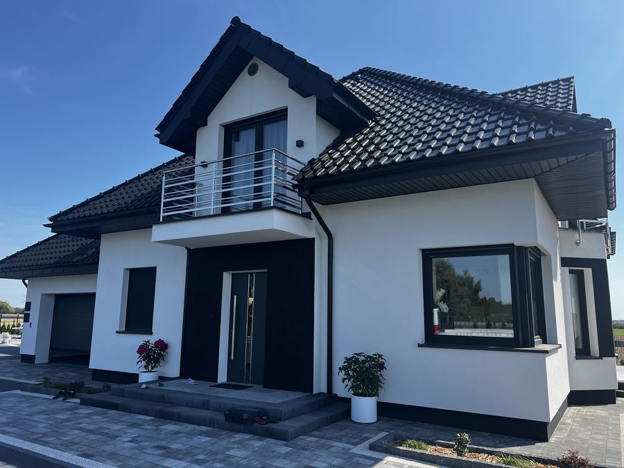 Dom jednorodzinny z antracytową stolarką okienną i drzwiami wejściowymi